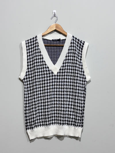 Black and white houndstooth V-neck sweater vest with white ribbed trim