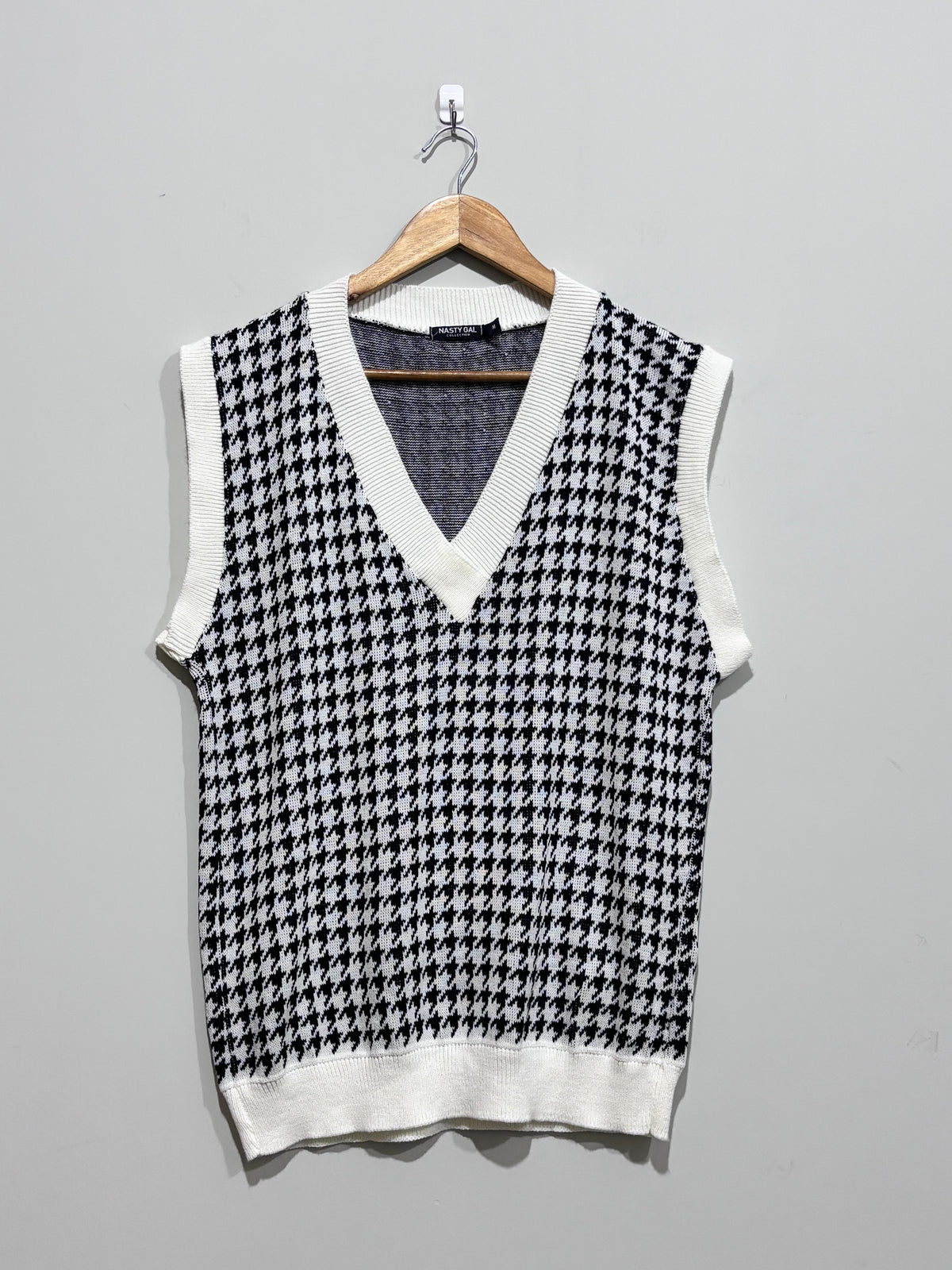 Black and white houndstooth V-neck sweater vest with white ribbed trim