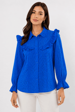 Woman wearing a blue blouse with ruffled details on a white background
