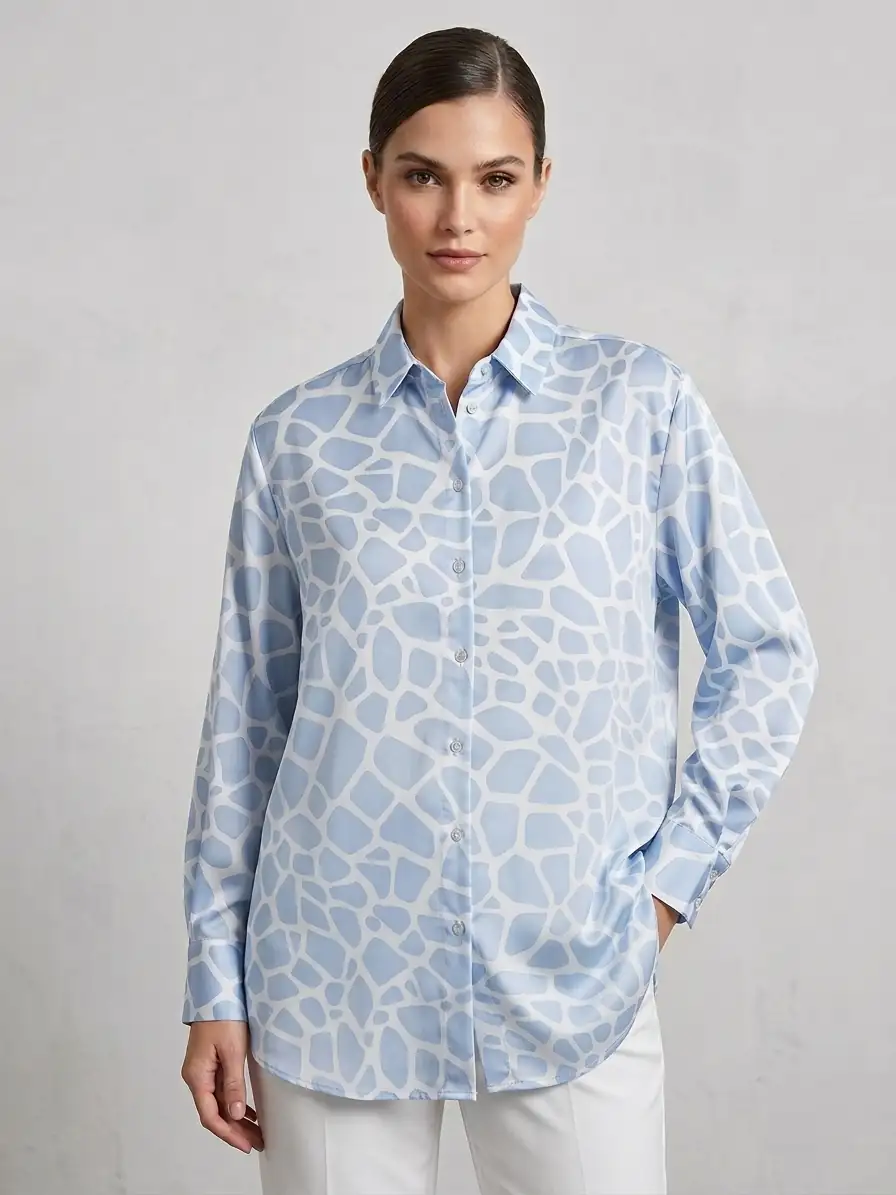 Woman wearing a light blue patterned shirt against a gray background