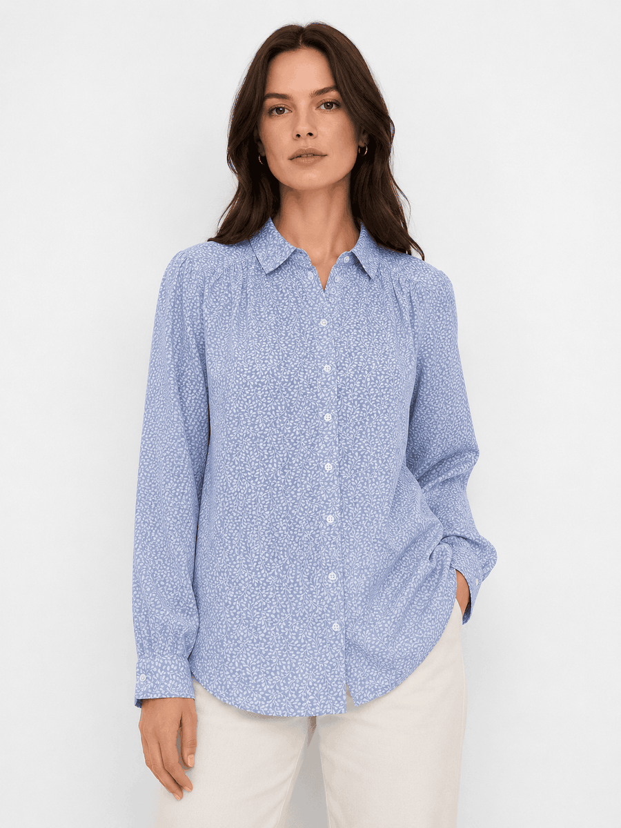 Woman wearing a blue patterned shirt against a white background