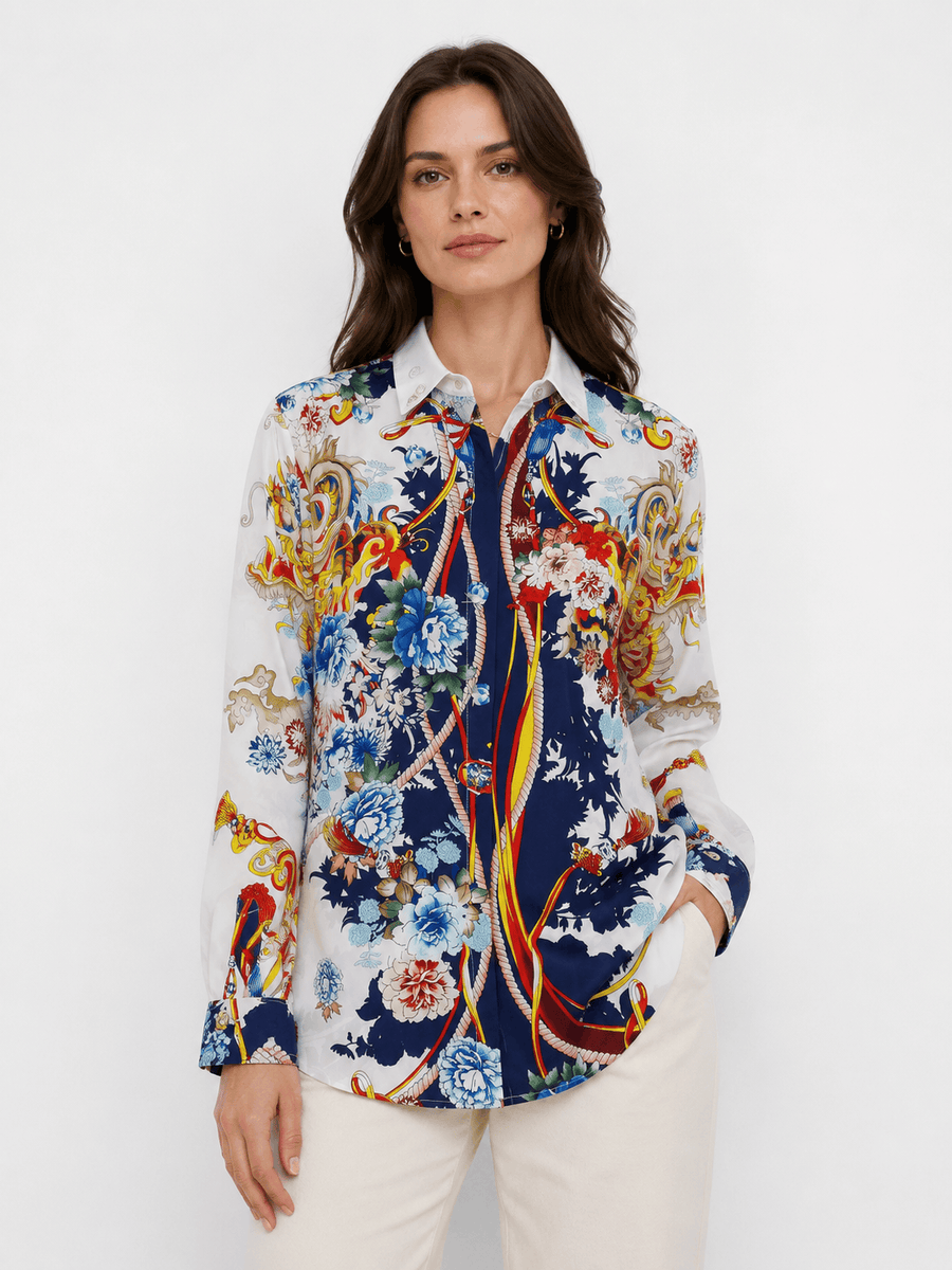 Woman wearing a colorful floral and paisley patterned shirt on a white background