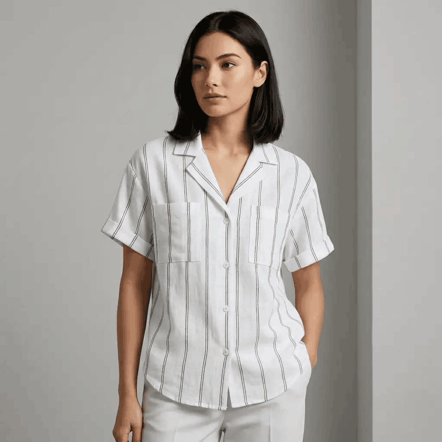 Woman wearing a white shirt with black stripes against a gray background