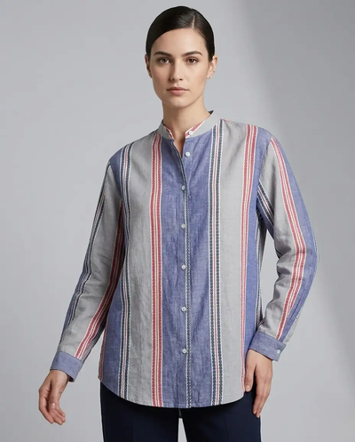 Woman wearing a long-sleeve, button-up shirt with a striped pattern on a gray background