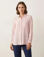 Woman wearing a light pink blouse with a plain background