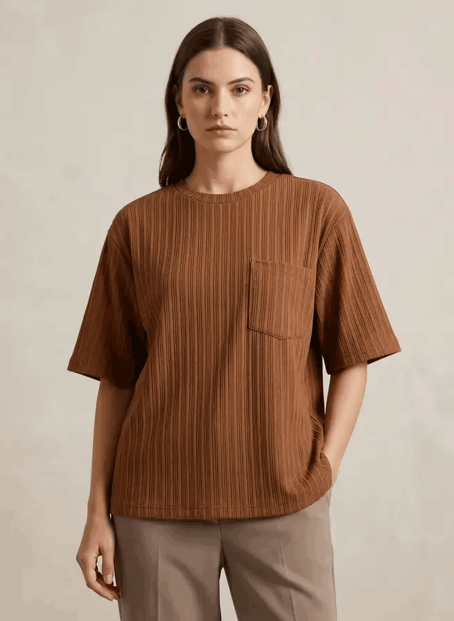 Woman wearing a brown ribbed t-shirt with a pocket on a beige background