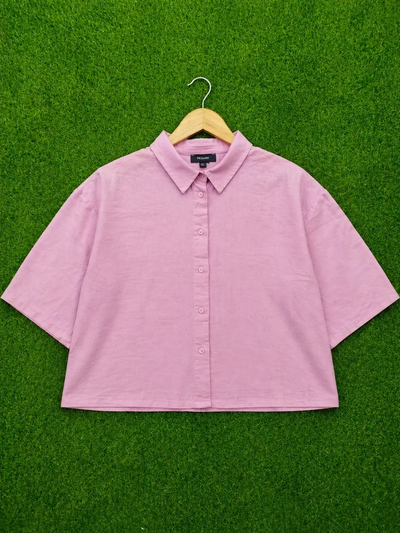 Pink shirt on a hanger against a green background - alternate view