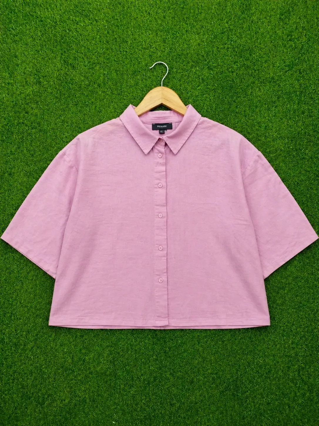 Pink shirt on a hanger against a green background