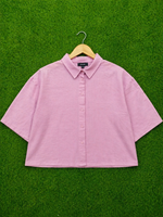 Pink shirt on a hanger against a green background