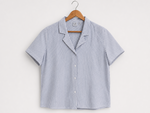 Striped shirt on a hanger against a white background