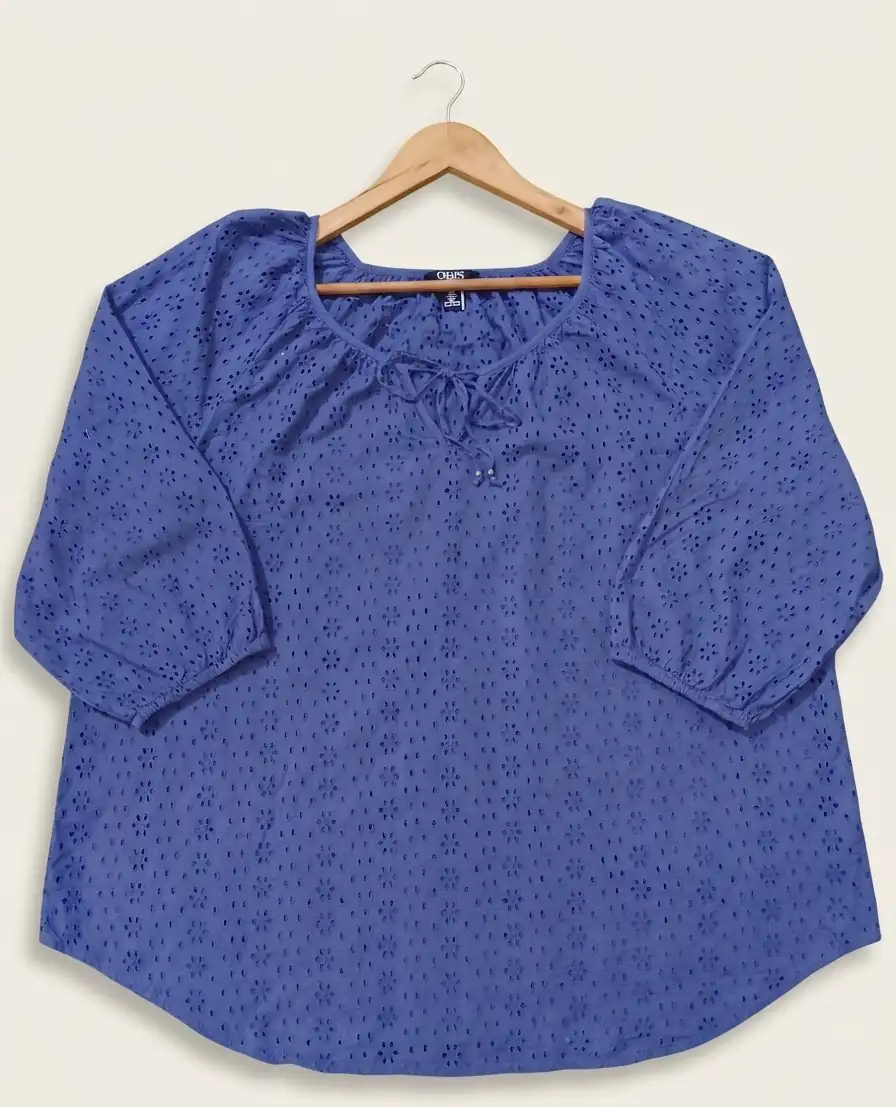 Blue blouse with a subtle pattern on a hanger against a white background