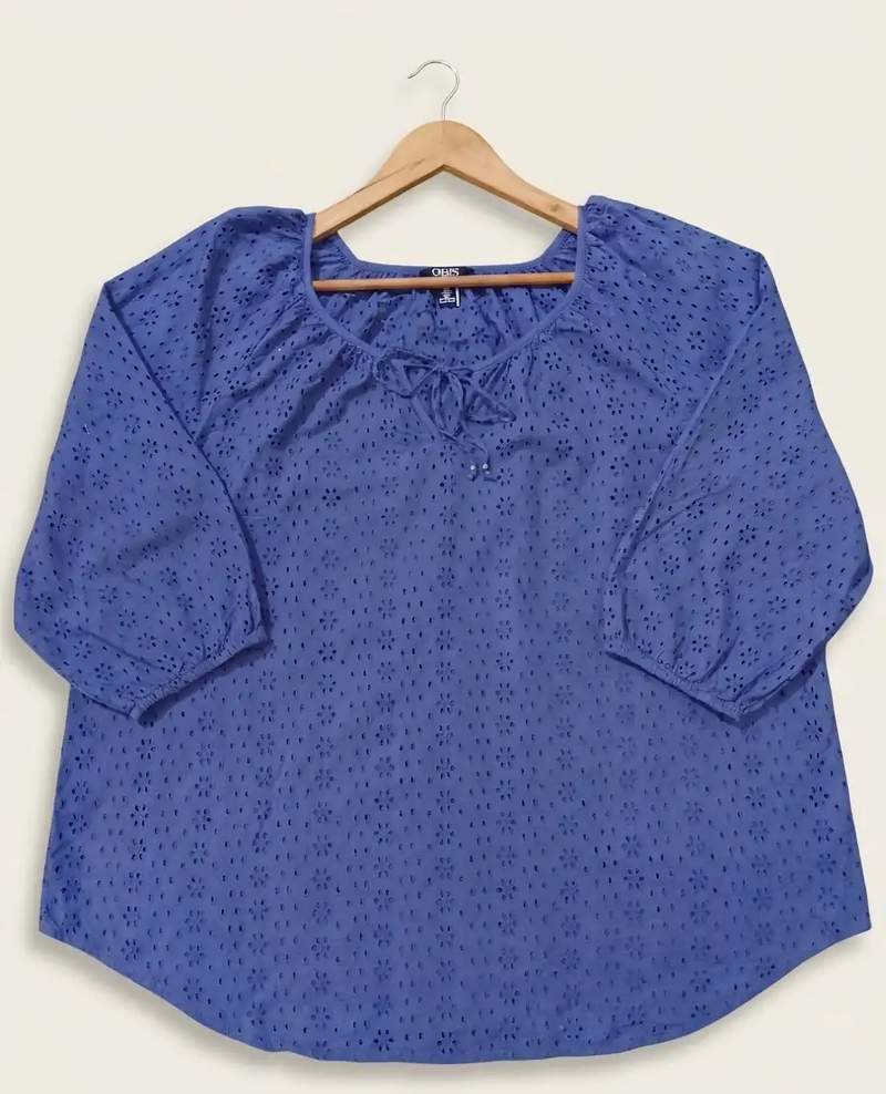 Blue blouse with a subtle pattern on a hanger against a white background