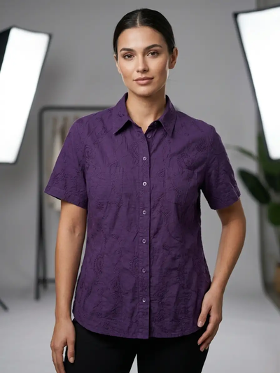 Woman wearing a purple patterned shirt in a studio setting