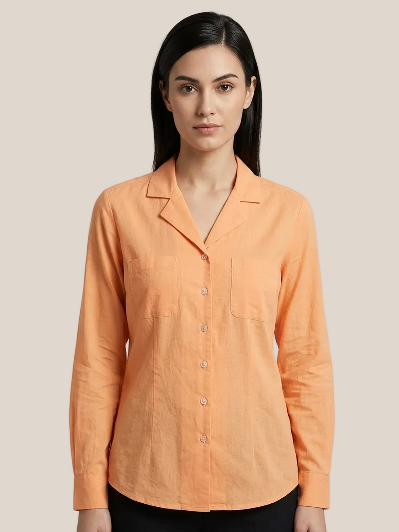Woman wearing an orange shirt against a gray background