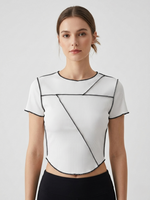 Woman wearing a white geometric-patterned top on a light gray background