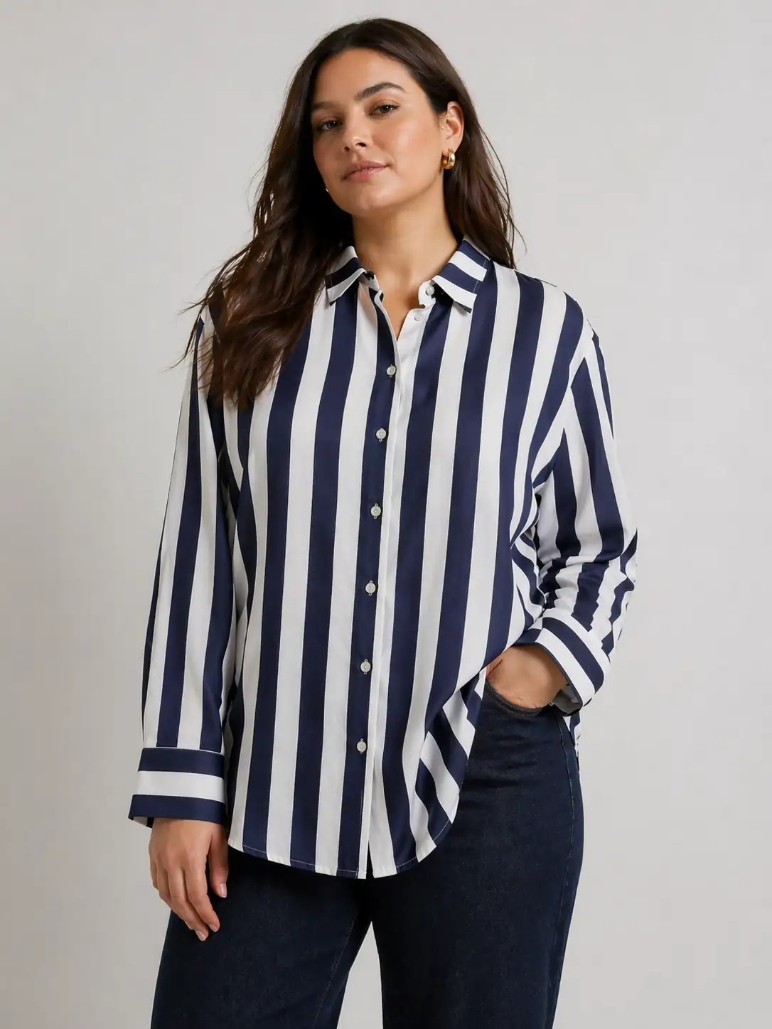 Woman wearing a navy and white striped shirt against a gray background
