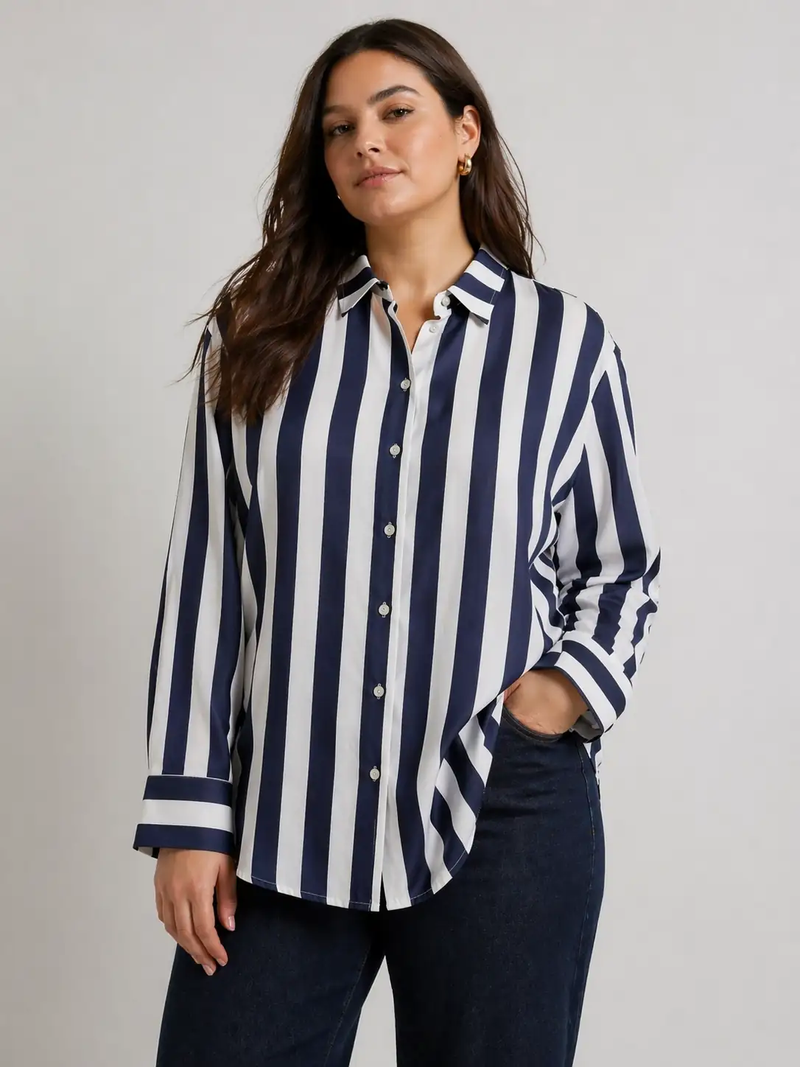 Woman wearing a navy and white striped shirt against a gray background
