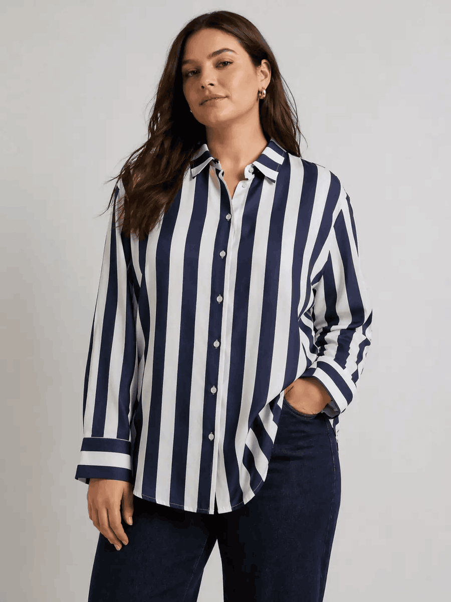 Woman wearing a navy and white striped shirt against a gray background