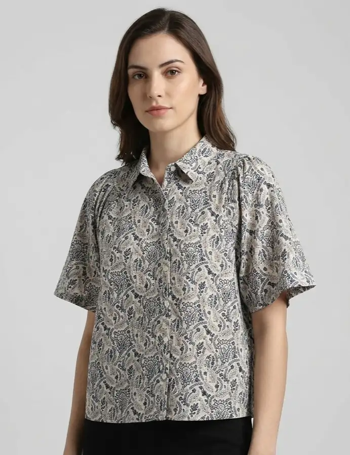 Woman wearing a patterned shirt against a plain background