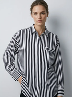 Woman wearing a black and white striped shirt against a plain background