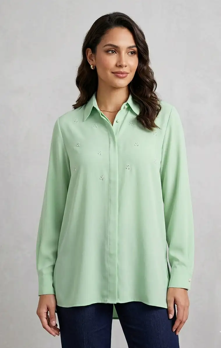 Woman wearing a light green shirt against a gray background