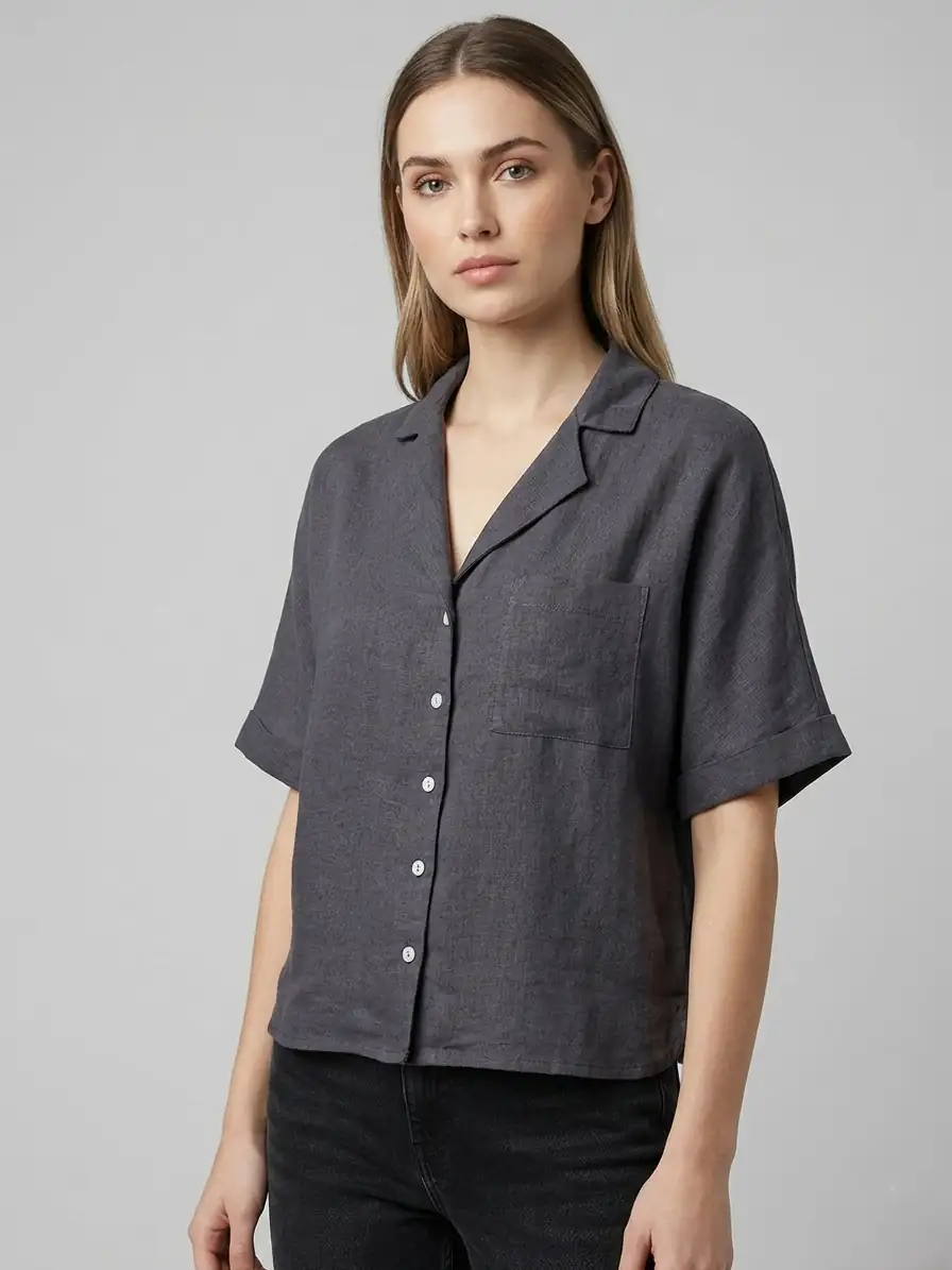 Woman wearing a dark gray short-sleeve shirt on a light gray background