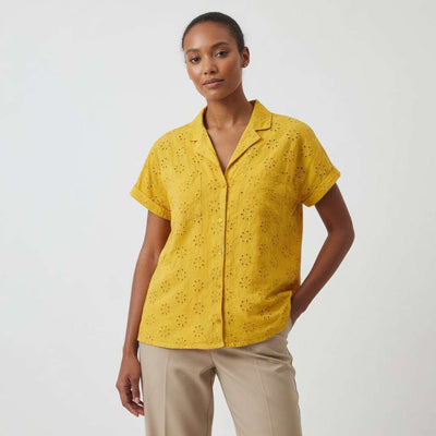 Woman wearing a yellow short-sleeve blouse with a white background
